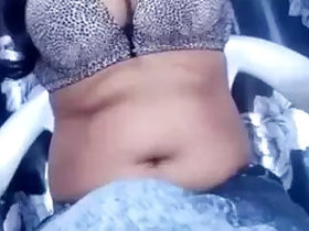 In a bra showing off her armpits and belly button for live teasing