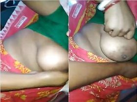 Desi Boudi presses her breasts with a Dewar.